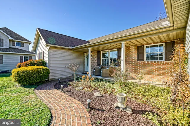a view of a hallway with wooden floor and a chandelier