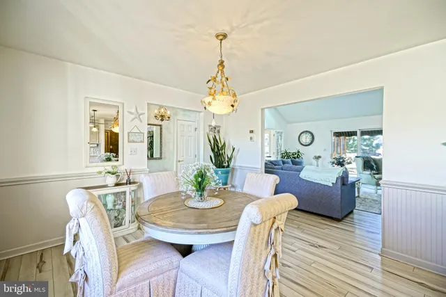 a kitchen with stainless steel appliances granite countertop a kitchen island hardwood floor sink stove dining table and chairs