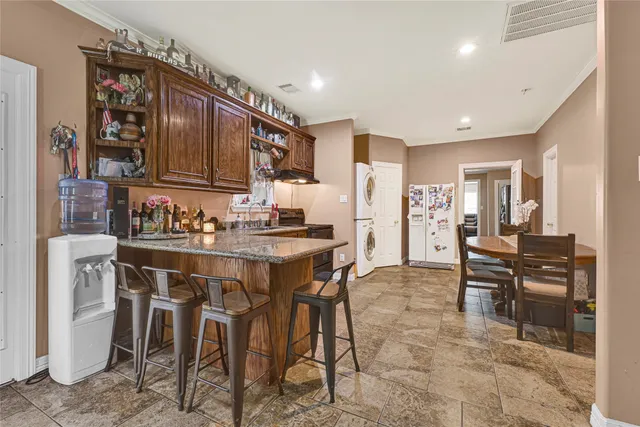 a kitchen with a dining table chairs and refrigerator
