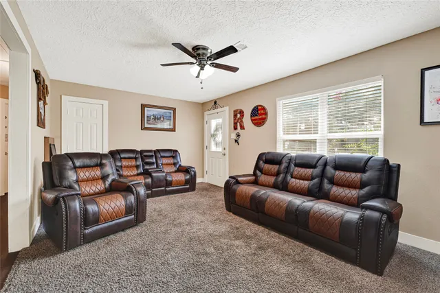a living room with furniture ceiling fan and a window