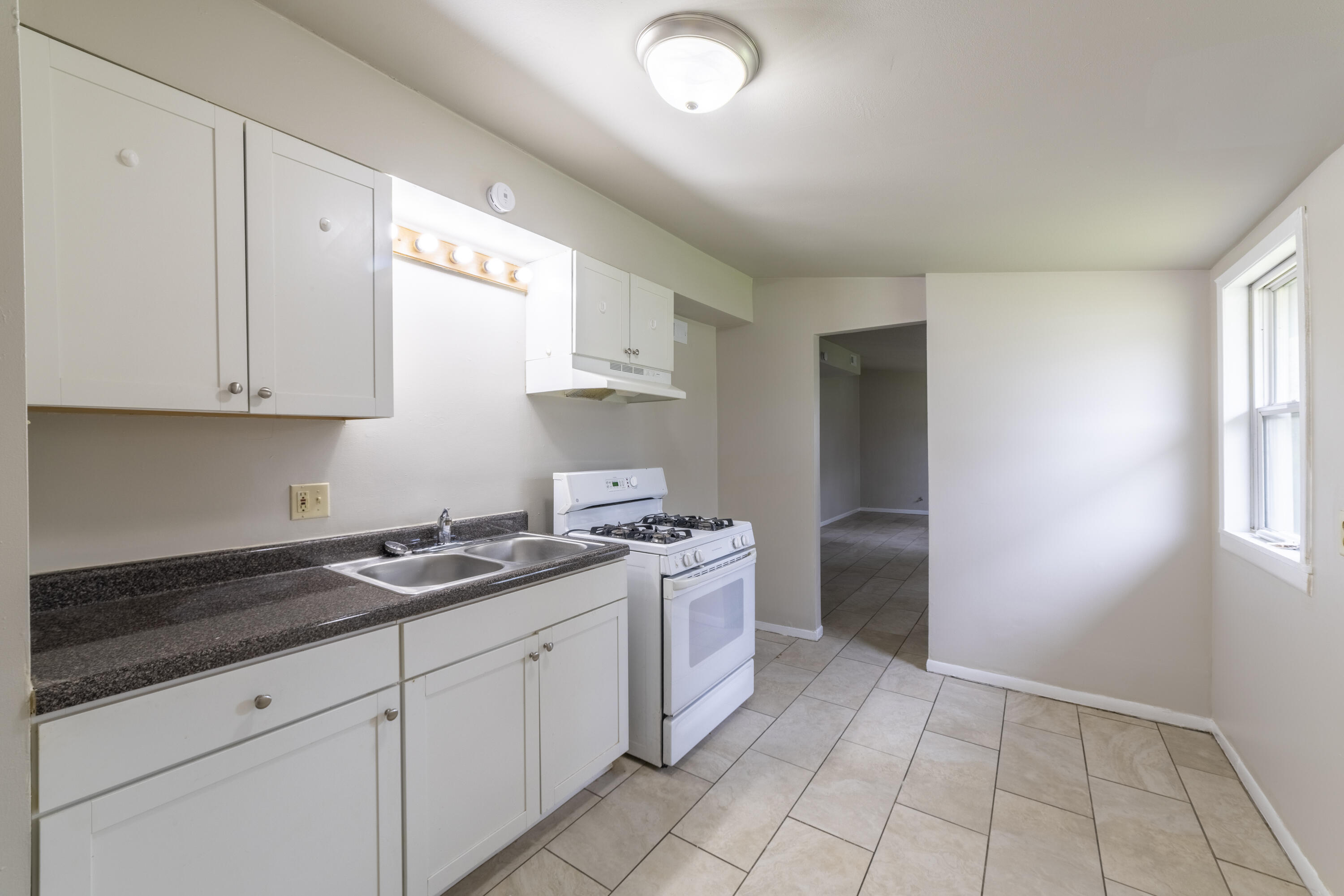 2280 Roosevelt Place Gary, IN 46404 - Photo 7 of 14 a kitchen with a stove a sink and a refrigerator