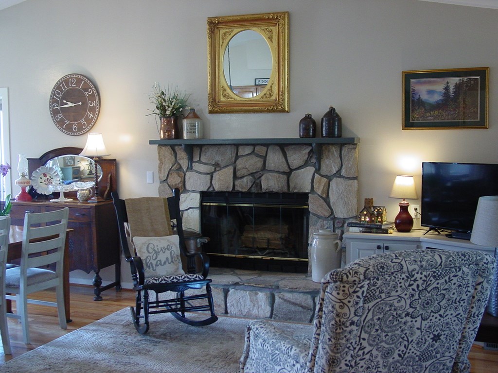 5170 Pine Crest Road Young Harris, GA 30582 - Photo 35 of 46 a living room with furniture a clock and a fireplace
