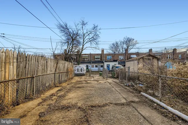 a view of a yard with wooden fence