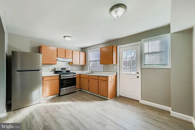 a kitchen with a refrigerator stove top oven and sink