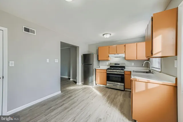 a kitchen with granite countertop wooden floors and stainless steel appliances