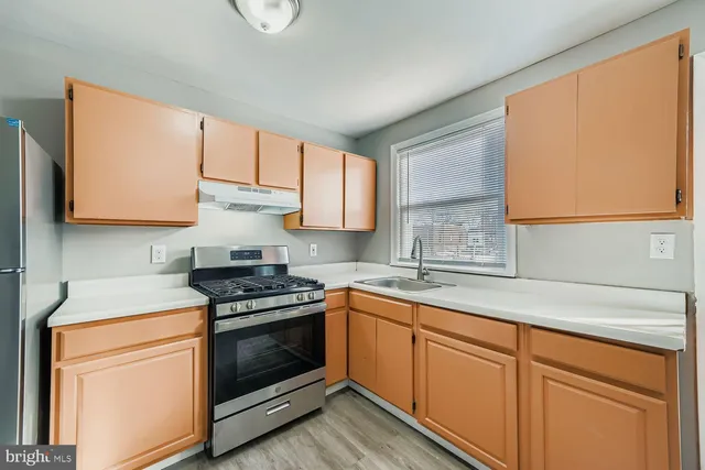 a kitchen with stainless steel appliances granite countertop a sink a stove and a microwave