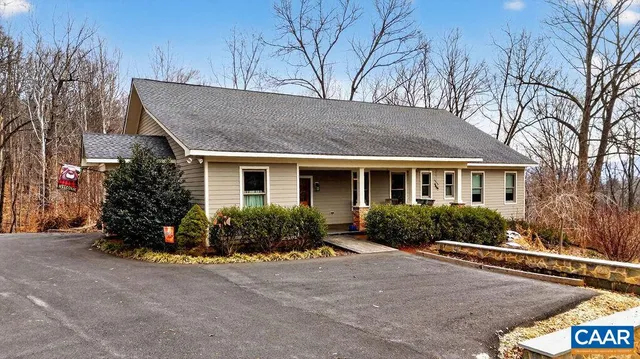 a front view of house with yard and trees in the background