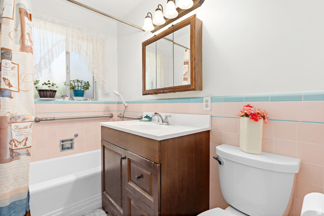 664 Wasatch Street Midvale, UT 84047 - Photo 12 of 33 Main bathroom with a 'three-boy' tub, a white sink, and a mirrored medicine cabinet