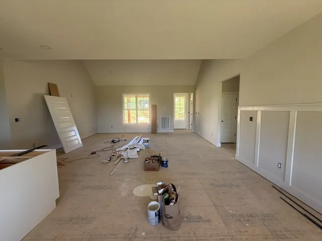 a living room with furniture and a refrigerator