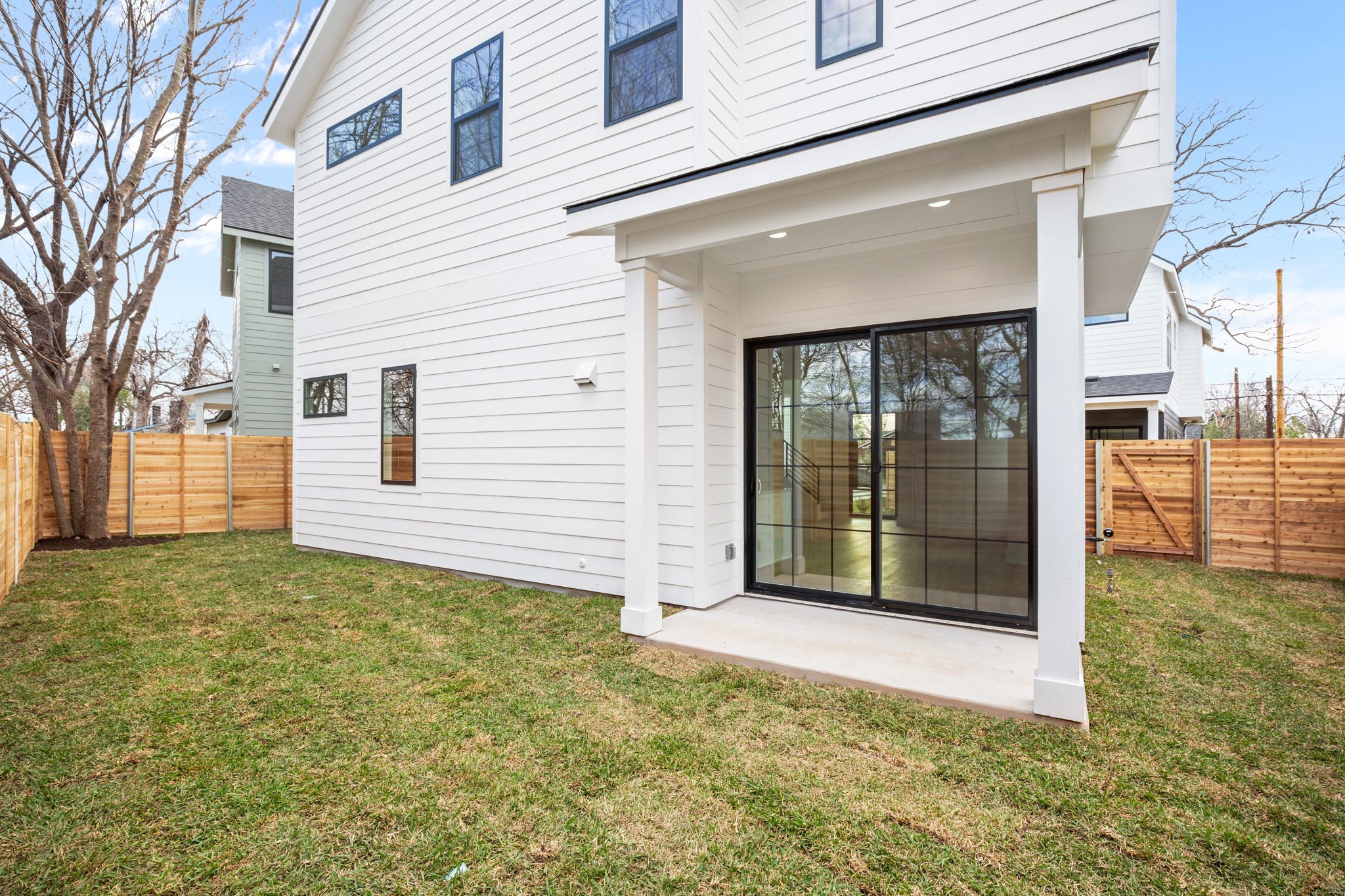 601 Vermont Road, Unit 2 Austin, TX 78702 - Photo 22 of 23 Private backyard space featuring a covered patio, a sliding glass door with grid detailing, and horizontal wood fencing