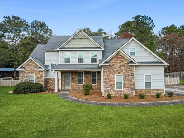 a front view of a house with a yard and green space