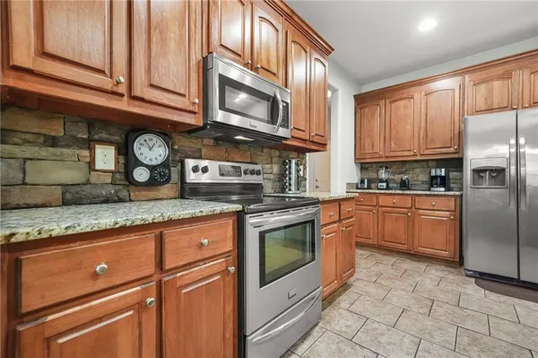 a kitchen with stainless steel appliances granite countertop a stove a sink and a microwave