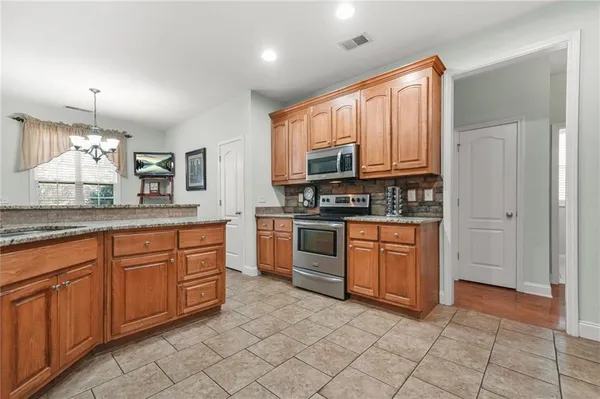 a kitchen with stainless steel appliances granite countertop a stove top oven a sink dishwasher and granite countertops with cabinets