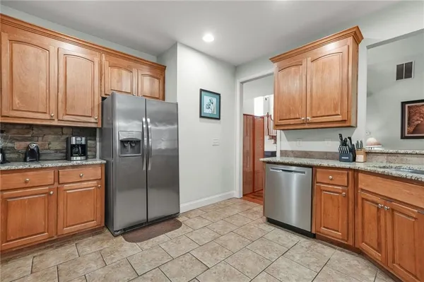 a kitchen with stainless steel appliances granite countertop a refrigerator sink and cabinets