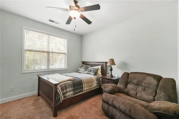 a bedroom with bed couch and window