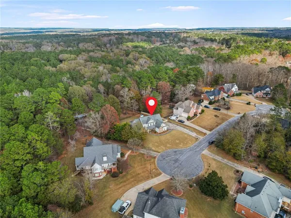 an aerial view of a house with a yard and lake view