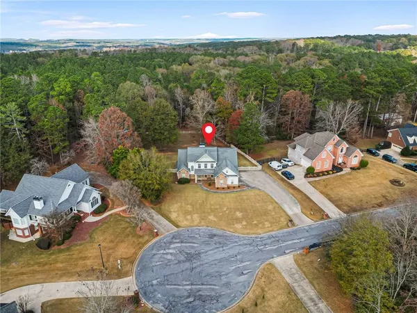 an aerial view of a houses with a yard and lake view