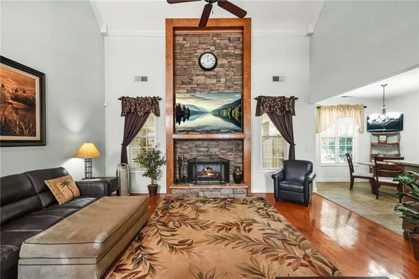 a living room with furniture a fireplace and a table with wooden floor