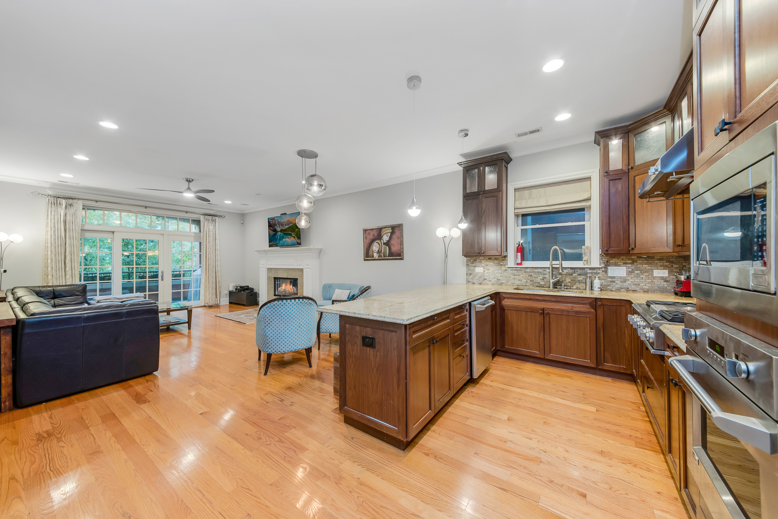 1238 West Jackson Boulevard, Unit 2W Chicago, IL 60607 - Photo 5 of 13 a large kitchen with stainless steel appliances granite countertop a lot of cabinets and wooden floor