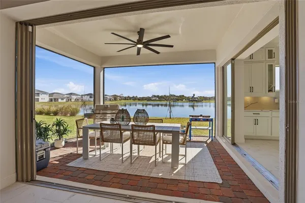 a kitchen with stainless steel appliances kitchen island granite countertop a table chairs and a sink