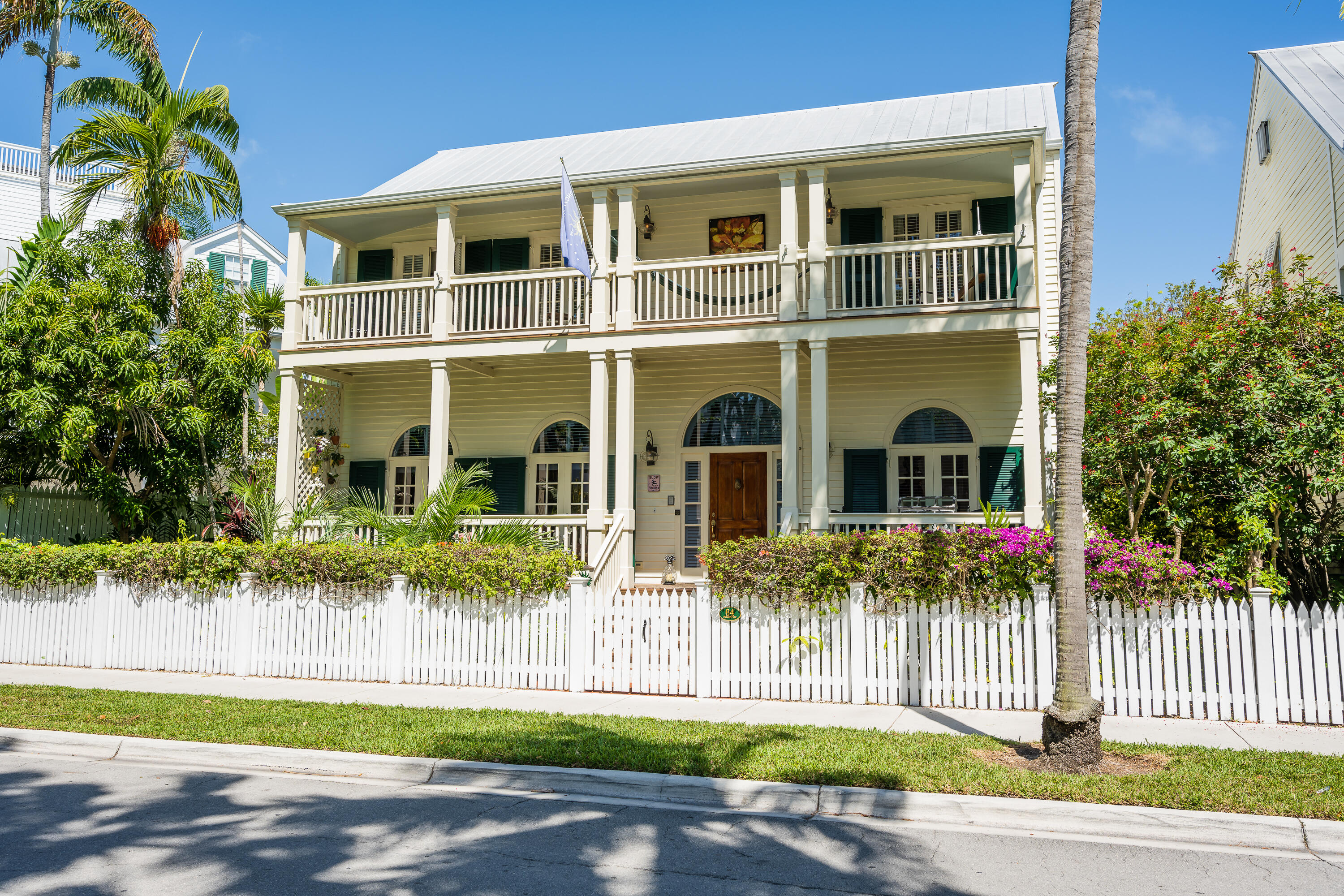 64 Front Street Key West, FL 33040 - Photo 2 of 5 a front view of a house with a garden and plants