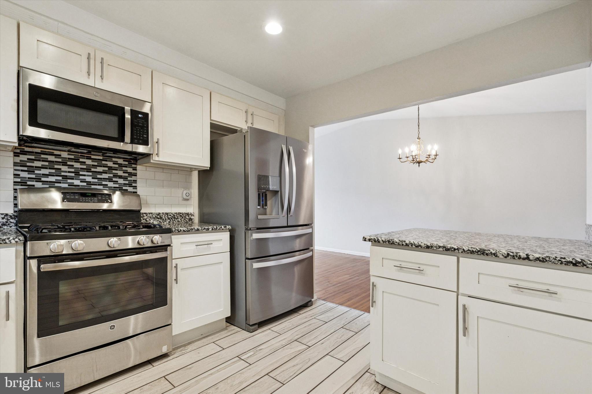 2678 Tremont Street Philadelphia, PA 19152 - Photo 12 of 24 a kitchen with granite countertop a stove and stainless steel appliances