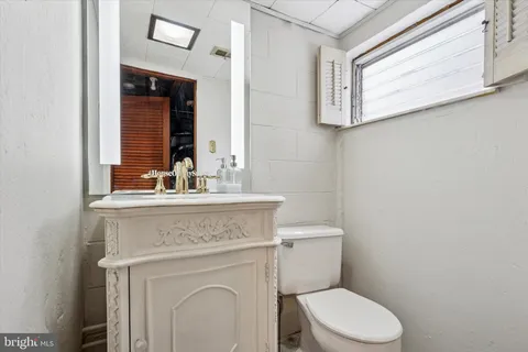 a bathroom with a granite countertop toilet sink and mirror