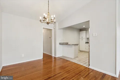 a view of a room with wooden floor and a ceiling fan