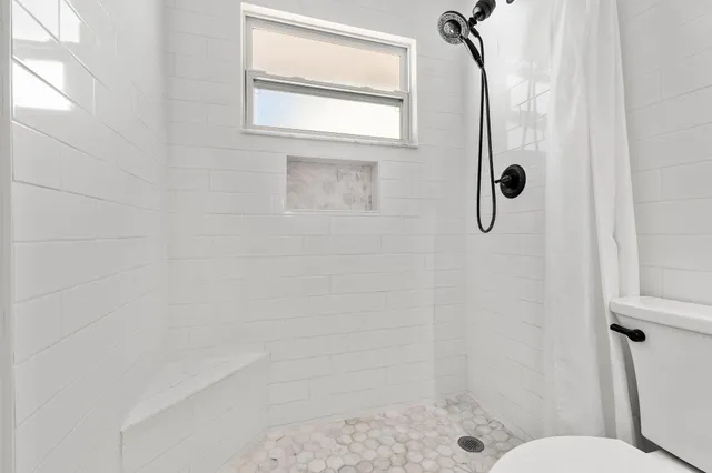 a bathroom with a shower and toilet