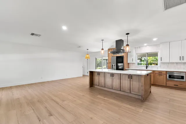 a kitchen with stainless steel appliances a refrigerator and a stove top oven