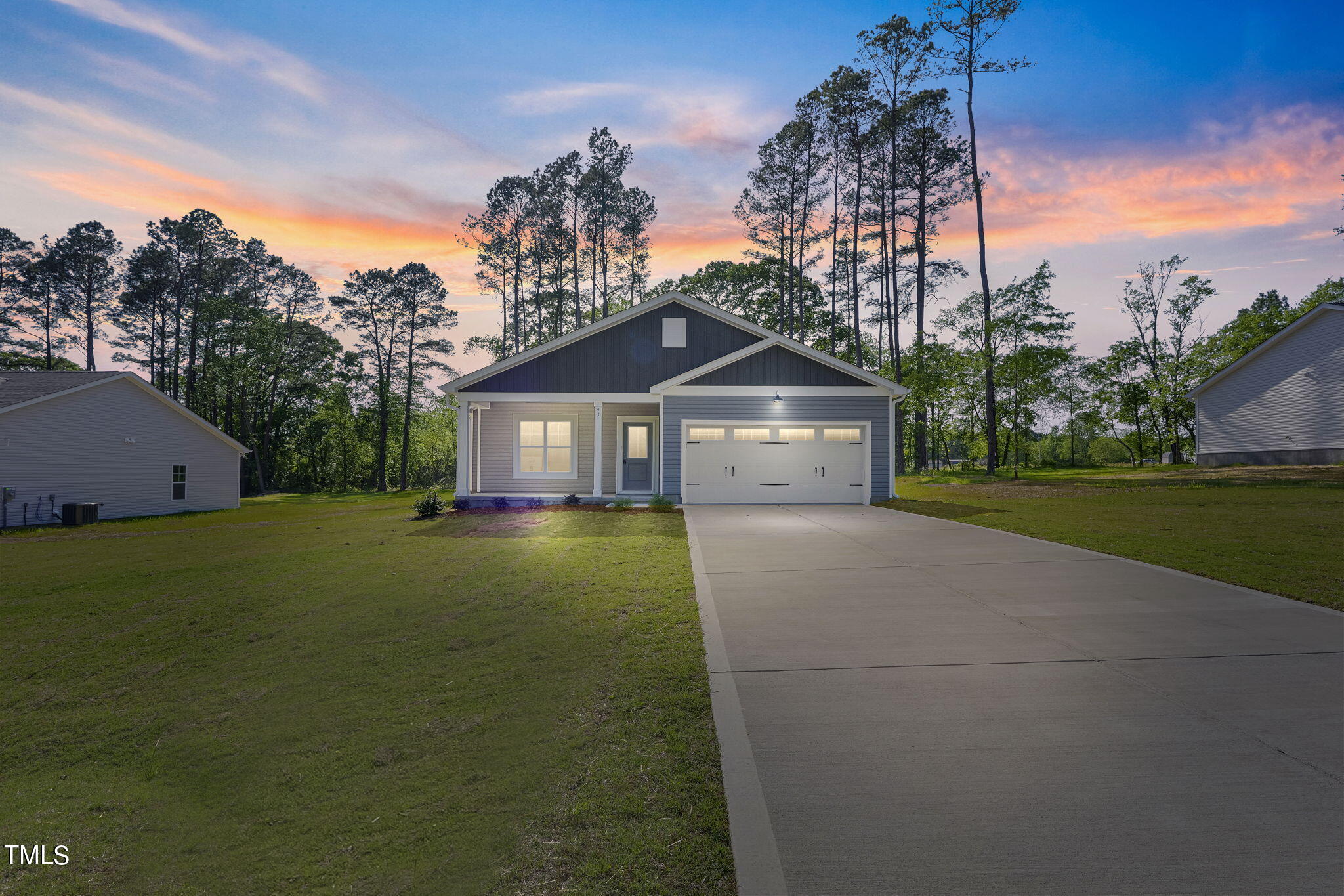 a front view of a house with a garden and trees