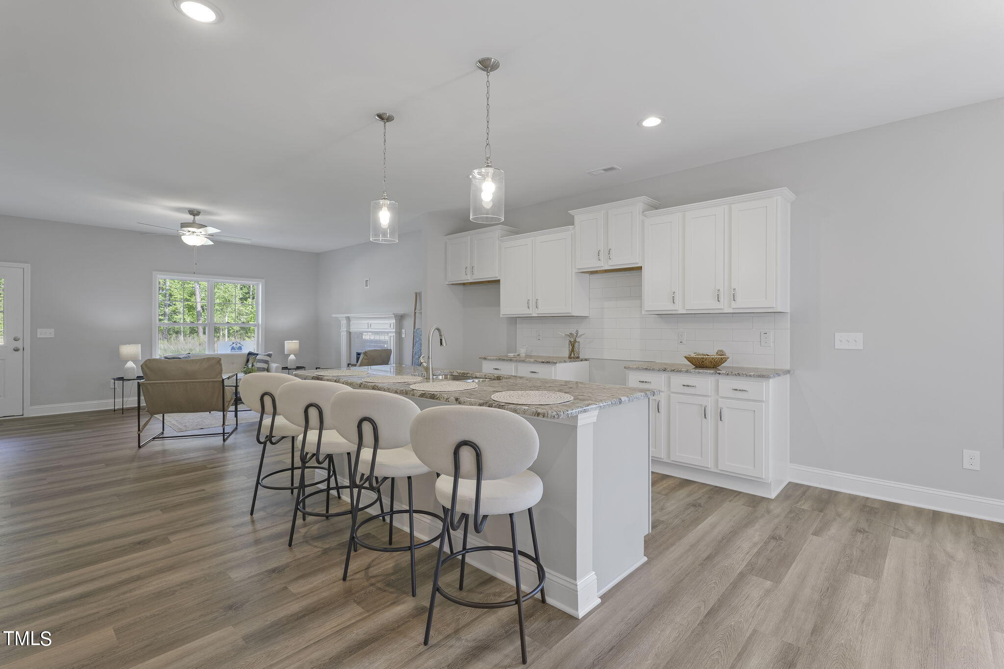 93 Regis Lane Coats, NC 27521 - Photo 15 of 31 a large kitchen with kitchen island granite countertop a dining table chairs and white cabinets