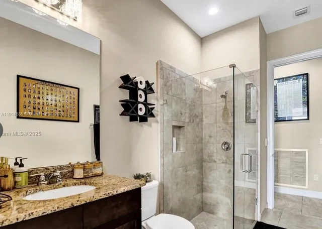 a bathroom with a granite countertop sink toilet and shower