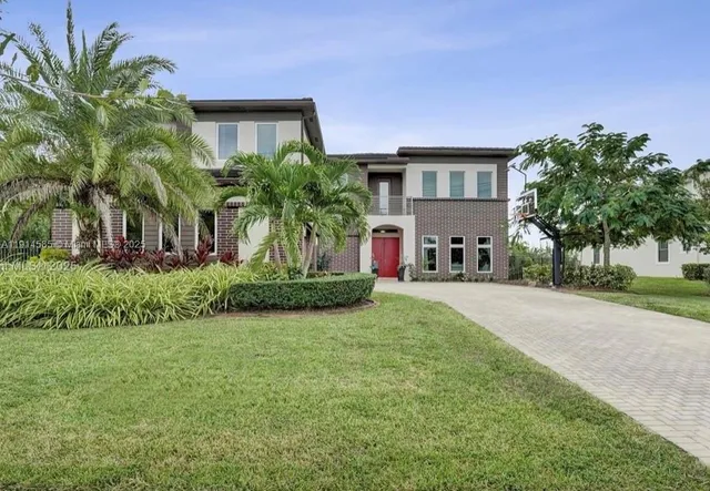 a front view of a house with a garden and plants
