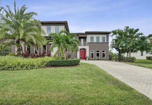 a front view of a house with a garden and plants