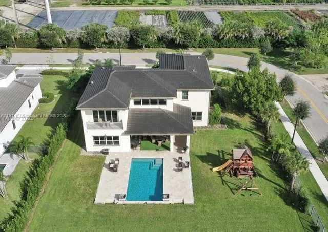 an aerial view of a house with swimming pool garden and patio