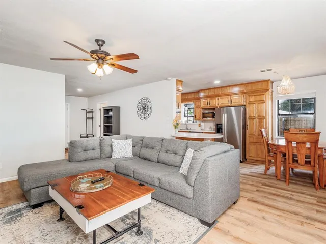 a living room with furniture a rug and a kitchen view