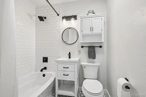 a bathroom with a sink a toilet and a mirror