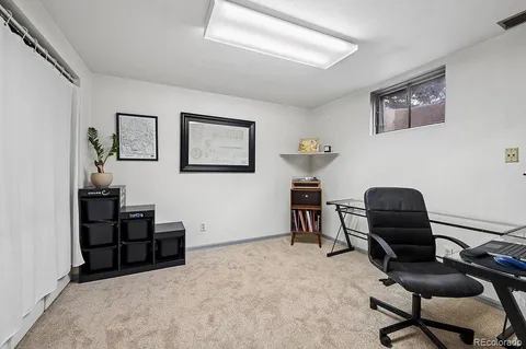 a living room with furniture and paintings on the wall