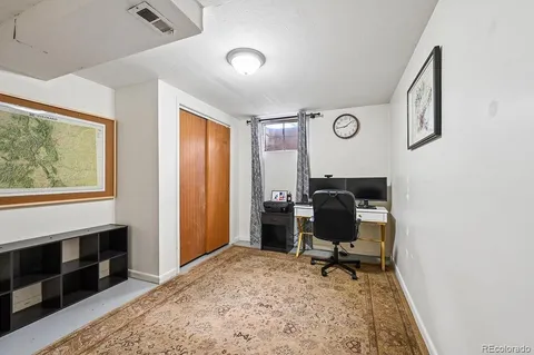 a view of a workspace with furniture and a window
