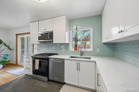 a kitchen with stainless steel appliances granite countertop a sink stove and cabinets
