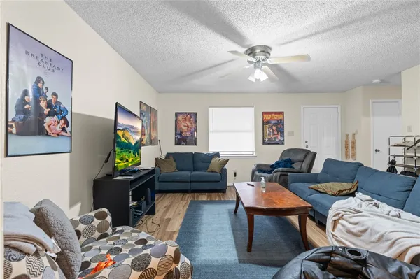 a living room with furniture a flat screen tv and a window
