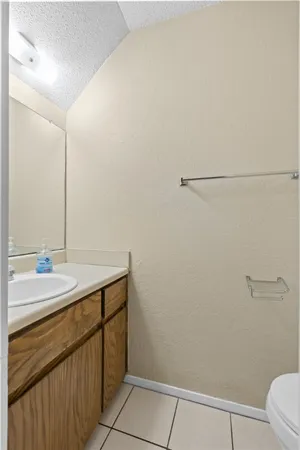 a bathroom with a granite countertop sink a toilet and a mirror