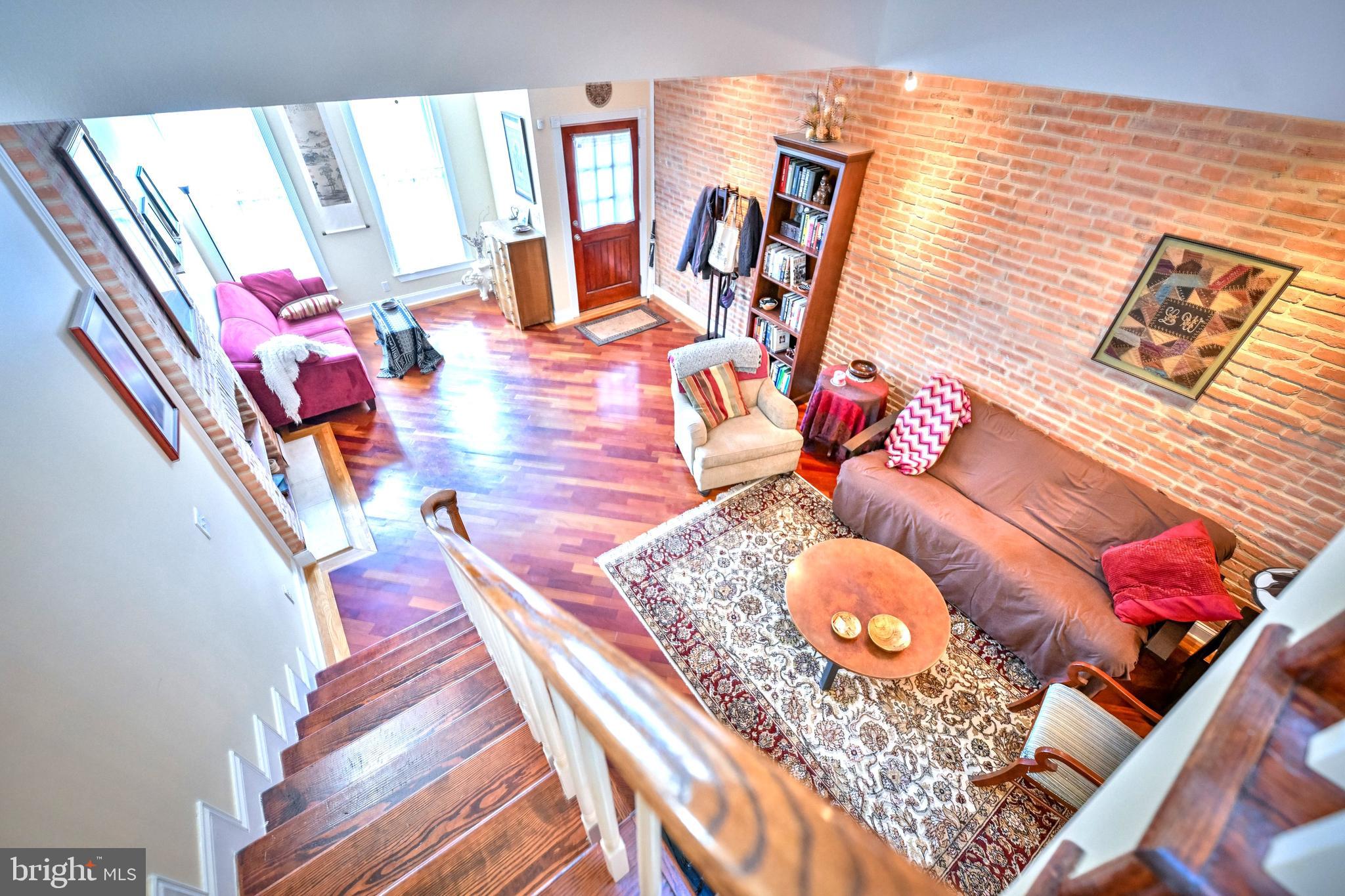 240 Wilson Street Baltimore, MD 21217 - Photo 11 of 63 Living room w/ HW FL & brick accent wall