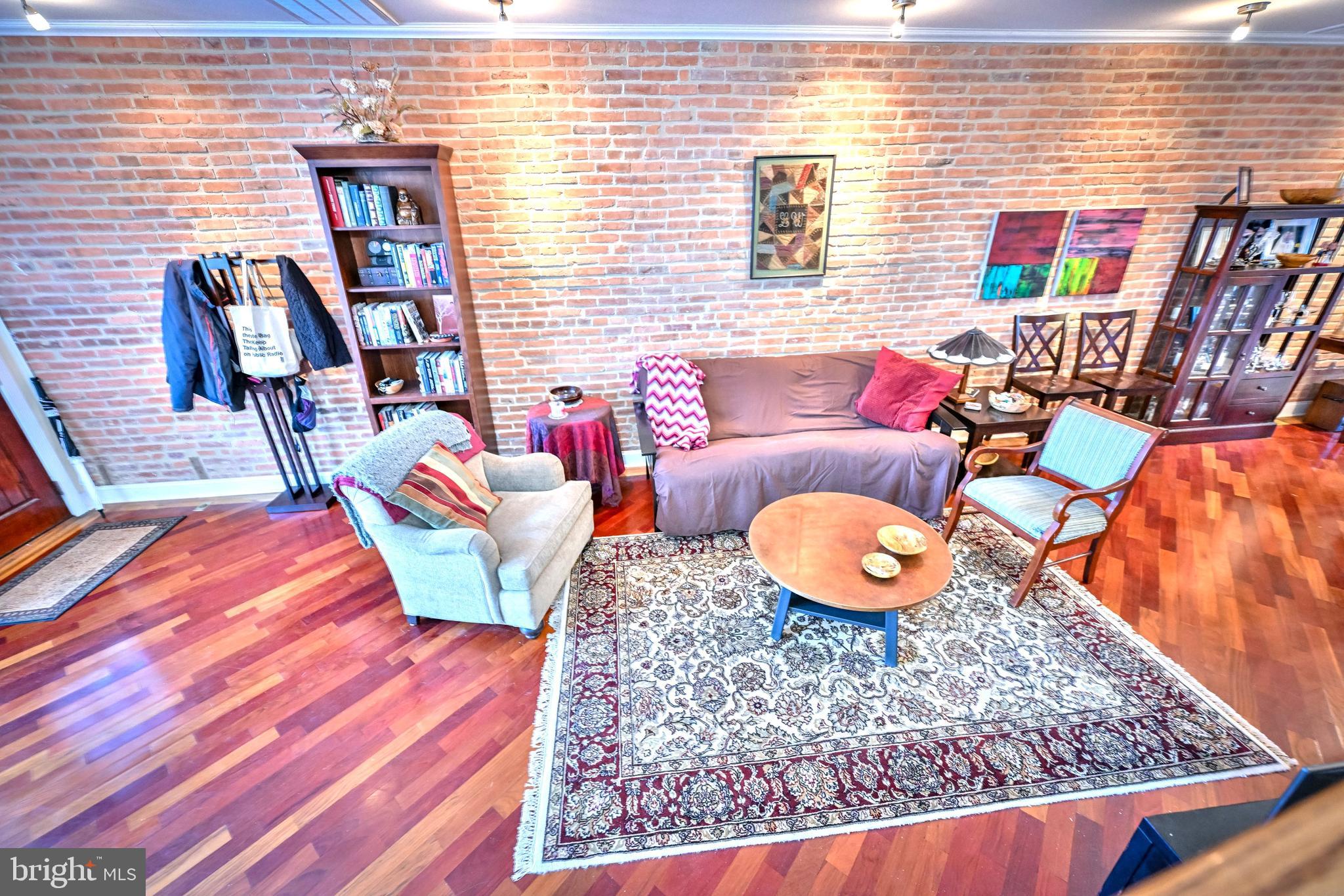 240 Wilson Street Baltimore, MD 21217 - Photo 12 of 63 Living room w/ HW FL & brick accent wall