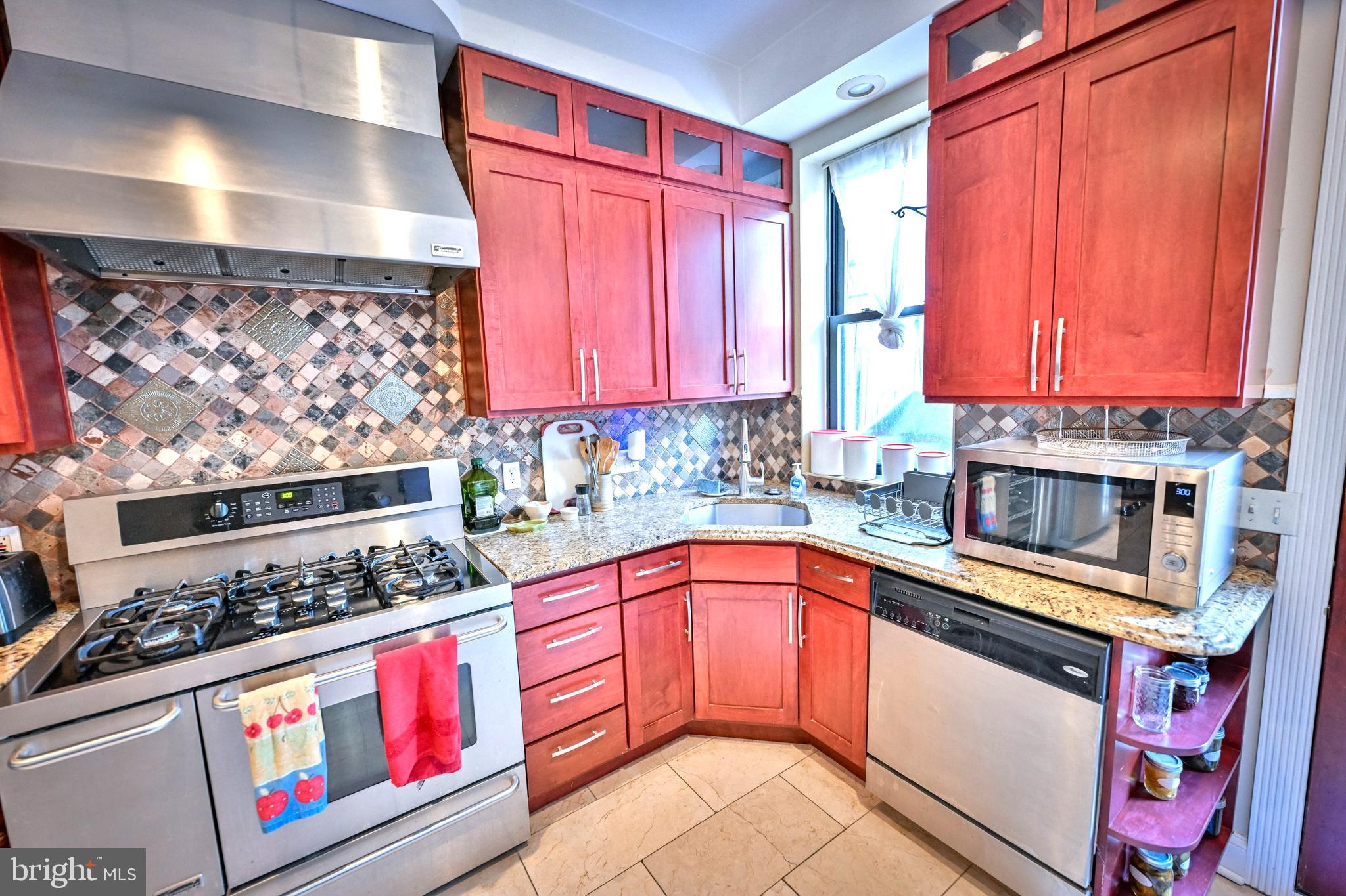 240 Wilson Street Baltimore, MD 21217 - Photo 21 of 63 a kitchen with stainless steel appliances granite countertop a stove a sink and a microwave