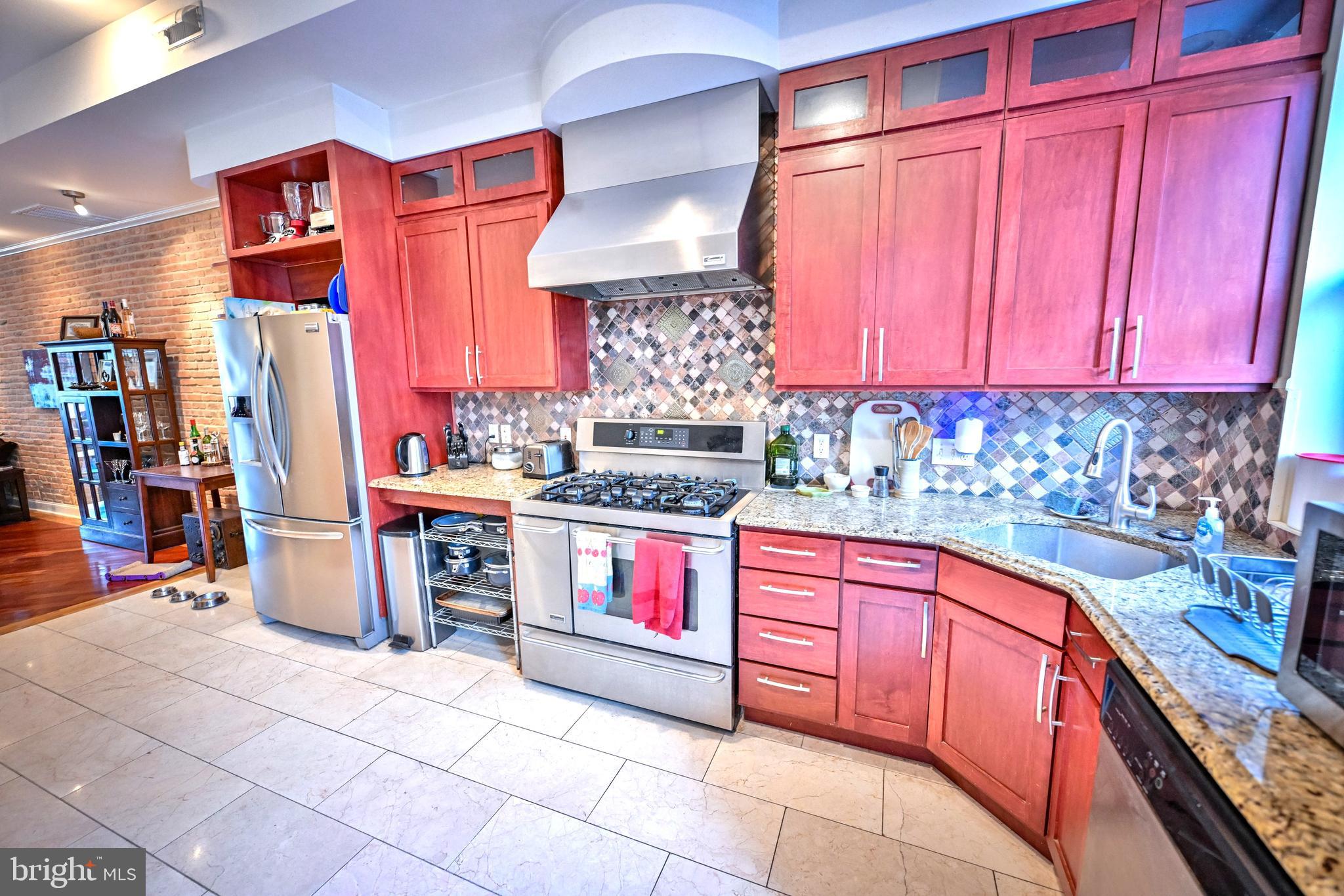240 Wilson Street Baltimore, MD 21217 - Photo 22 of 63 a kitchen with stainless steel appliances granite countertop a stove a sink and a refrigerator