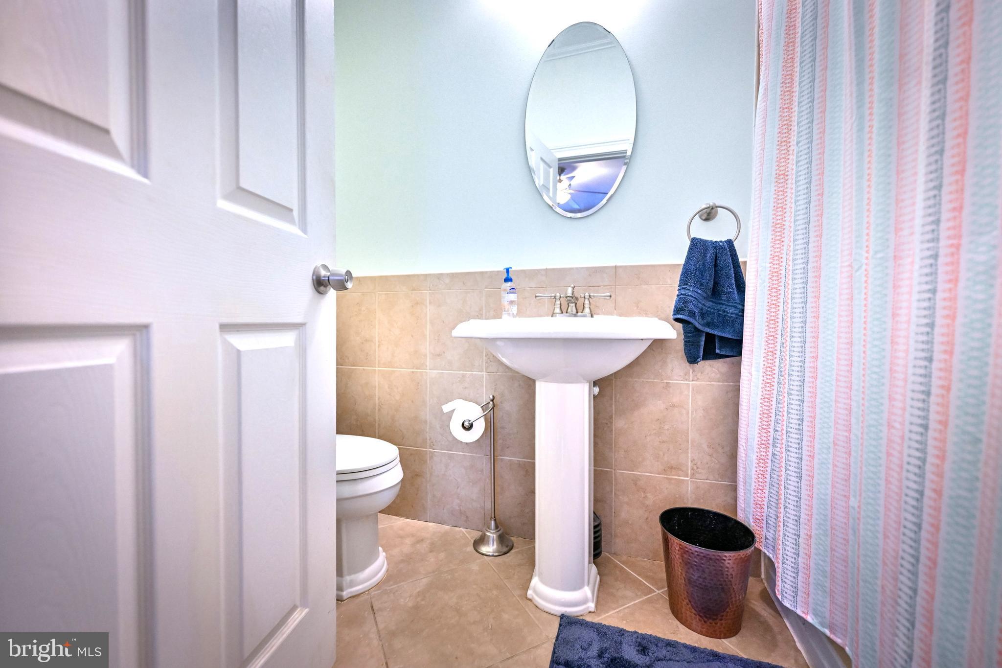 240 Wilson Street Baltimore, MD 21217 - Photo 30 of 63 a bathroom with a sink and mirror with toilet