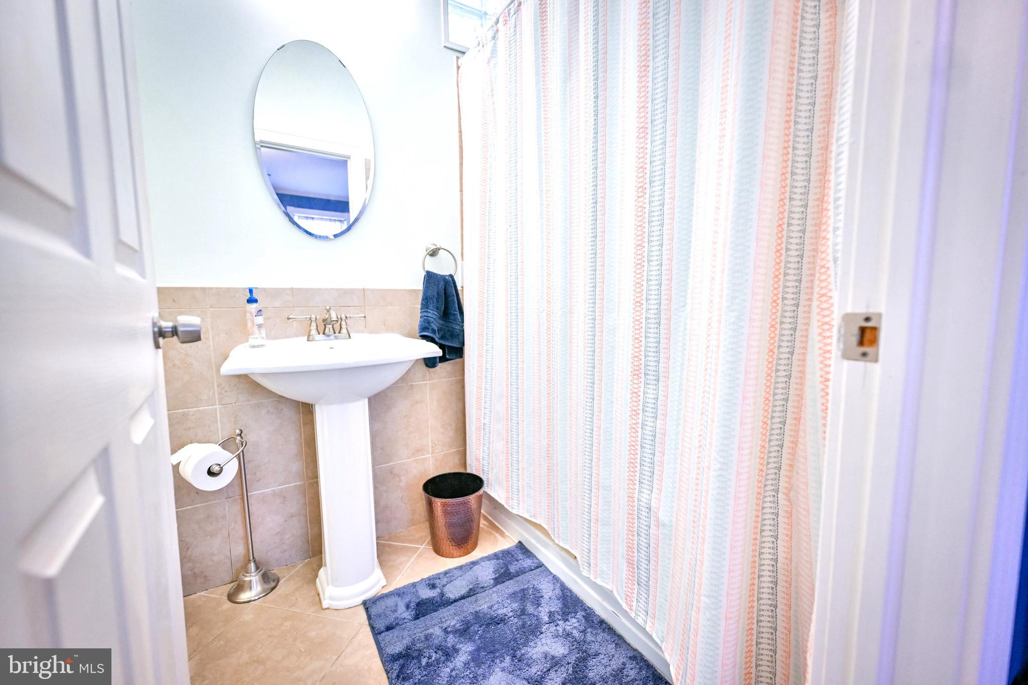 240 Wilson Street Baltimore, MD 21217 - Photo 31 of 63 a bathroom with a sink a mirror and toilet