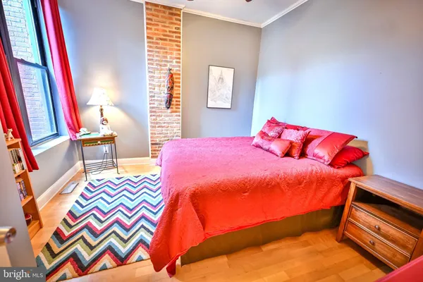 a bedroom with a bed and wooden floor